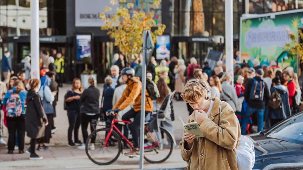 person läser utanför en mässa